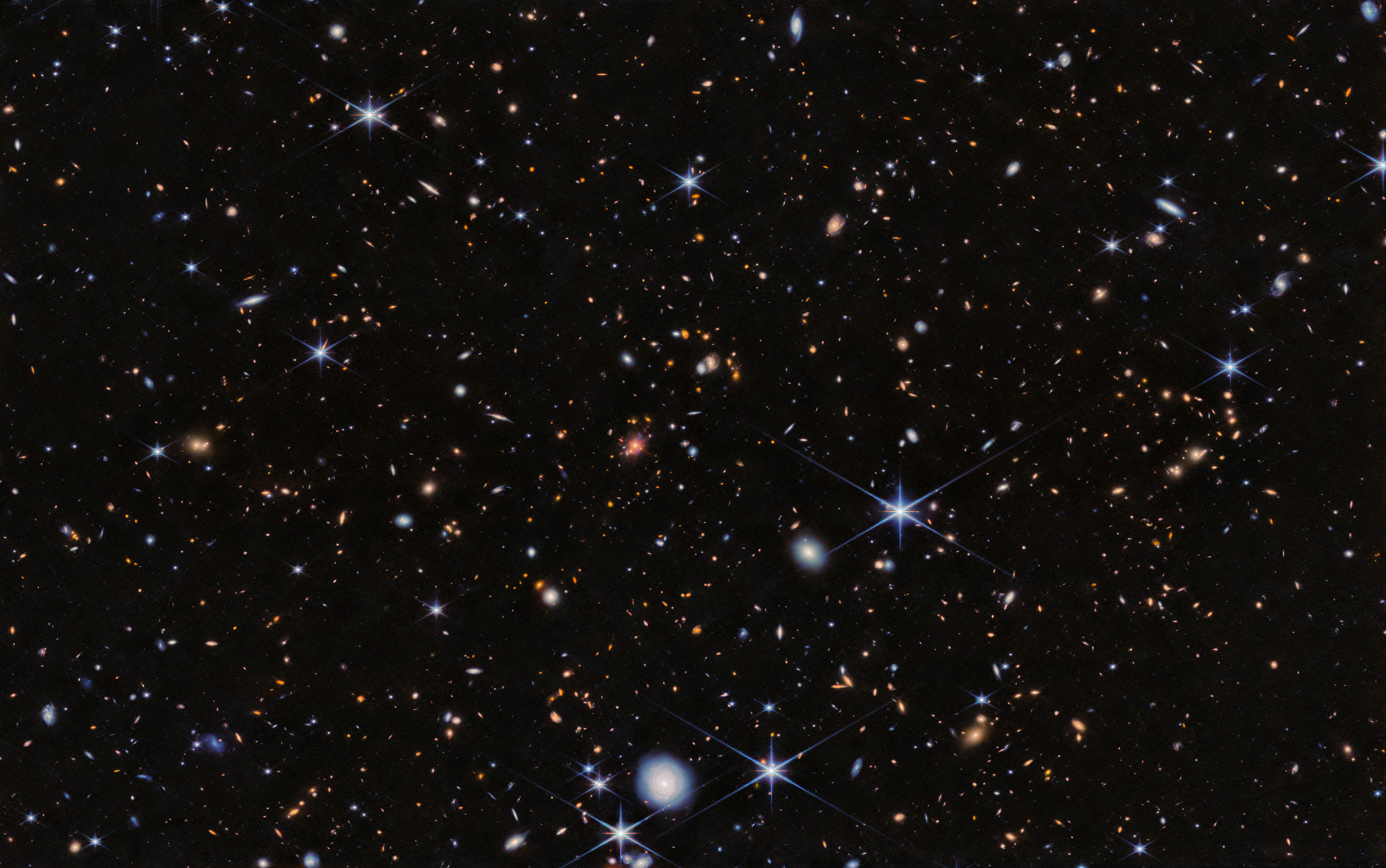 An image from the James Webb Space Telescope of the Spiderweb Protocluster, suffused with JWST's characteristic 6 pointed stars and both nearby and distant galaxies